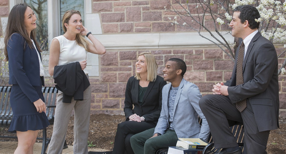 Law students converse outside the law school in spring.