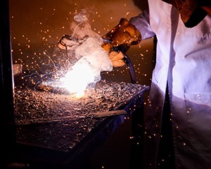 Worker welding in factory