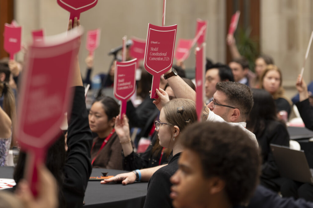 Students holding WashU Law signs at a campus event