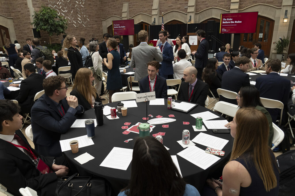 Attendees networking at round tables during a WashU Law event